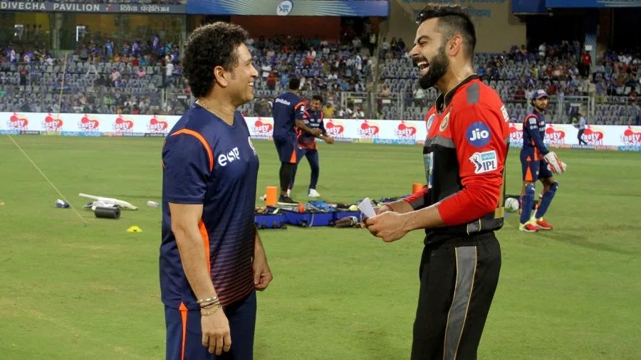 Cricketers Virat Kohli and Sachin Tendulkar on the ground